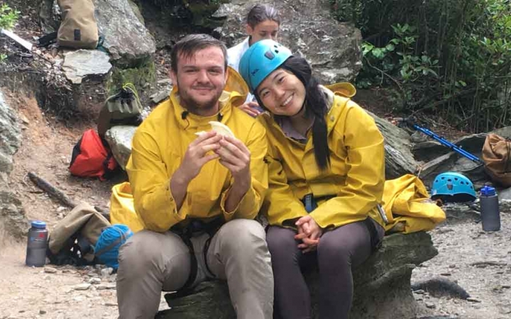two gap year students rest on a rock on an outward bound expedition in the blue ridge mountains